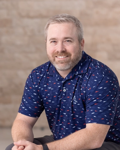 portrait of a smiling person in a collared shirt